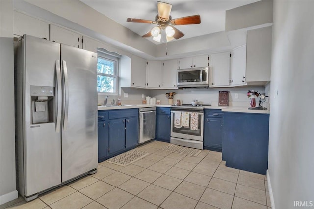 kitchen featuring blue cabinetry, white cabinetry, stainless steel appliances, and light tile patterned floors