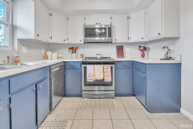 kitchen featuring blue cabinets, appliances with stainless steel finishes, and light tile patterned flooring