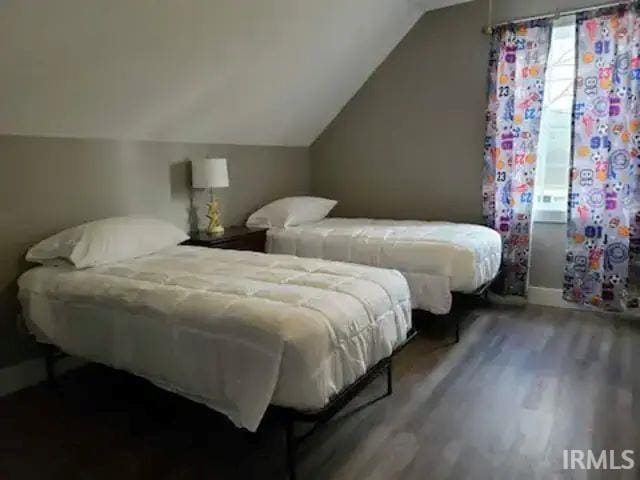 bedroom with vaulted ceiling and hardwood / wood-style floors