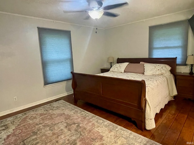 bedroom with ornamental molding, ceiling fan, and dark wood-type flooring