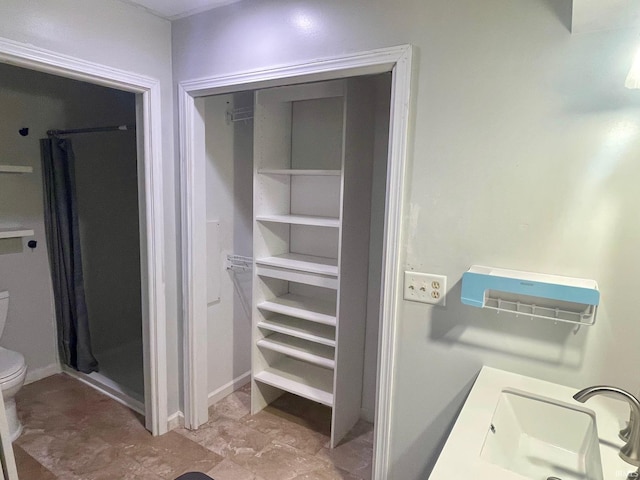 bathroom featuring a shower with curtain, sink, and toilet