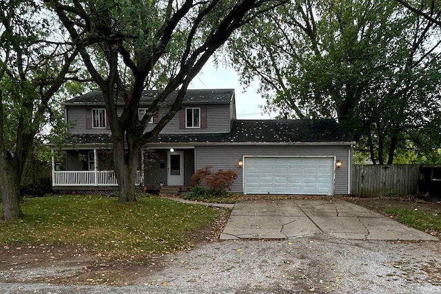 front facade featuring a front lawn, covered porch, and a garage