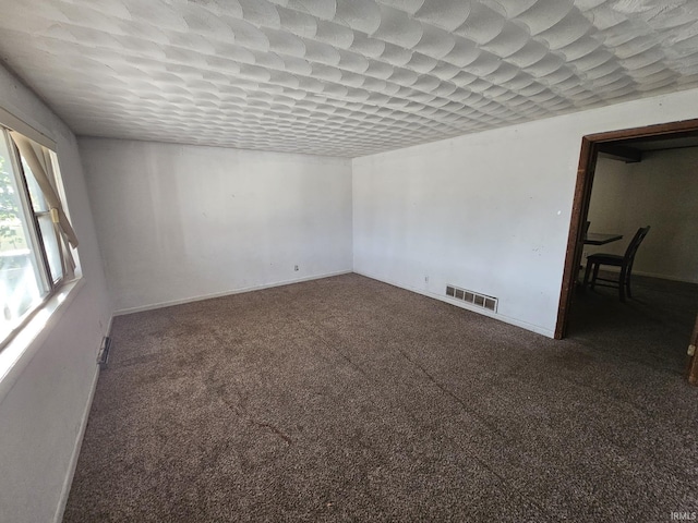 unfurnished room with dark carpet