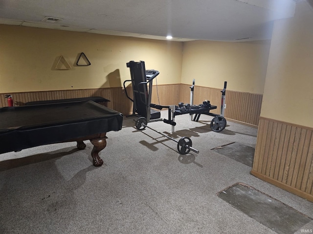 interior space with pool table, wooden walls, and light colored carpet