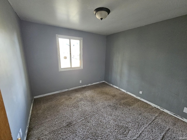 spare room with dark colored carpet