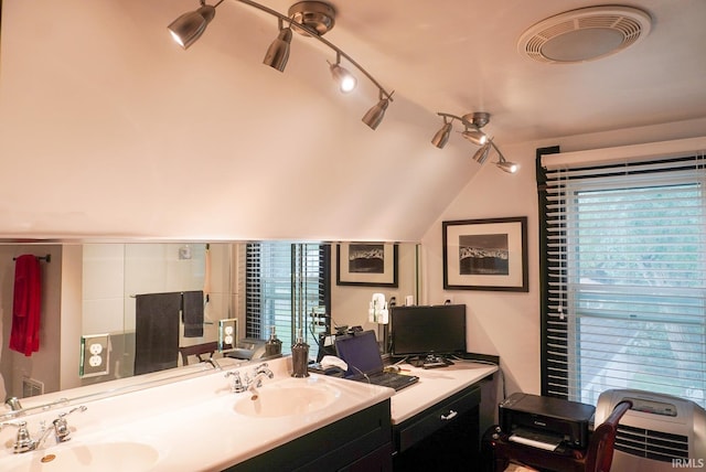 bathroom featuring vaulted ceiling, plenty of natural light, and sink