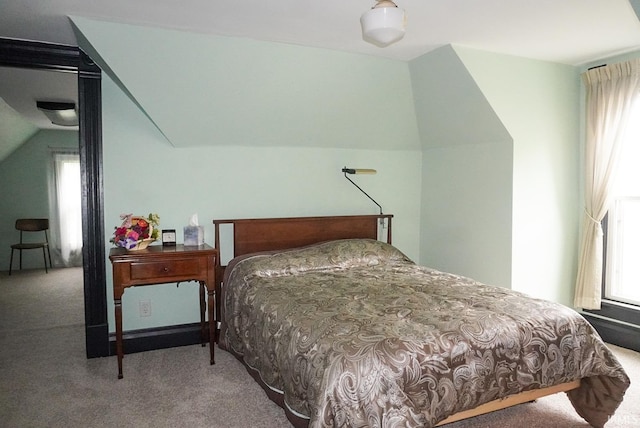 bedroom featuring lofted ceiling and carpet