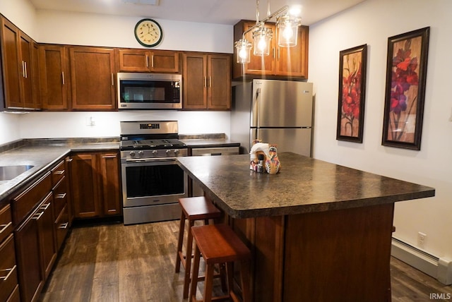 kitchen with a breakfast bar, a kitchen island, dark hardwood / wood-style flooring, stainless steel appliances, and a baseboard radiator