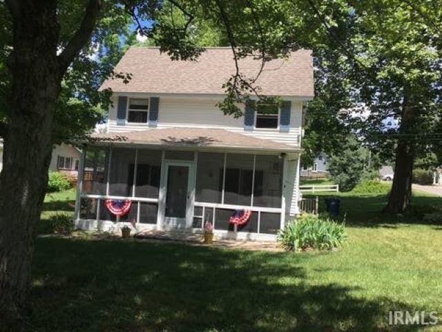 back of house featuring a lawn and a sunroom