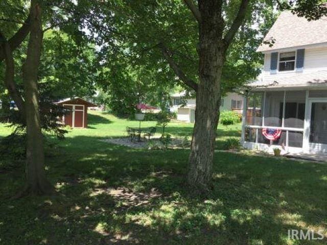 view of yard featuring a shed and a sunroom