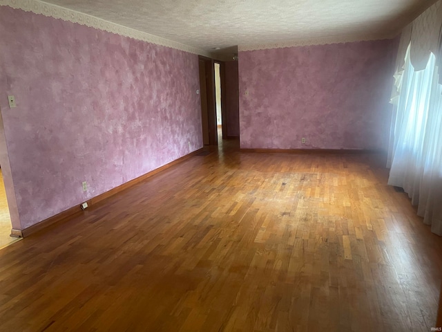 unfurnished room featuring a textured ceiling and hardwood / wood-style floors