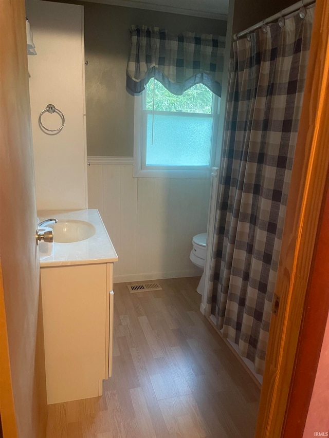 bathroom featuring a shower with shower curtain, hardwood / wood-style flooring, vanity, and toilet