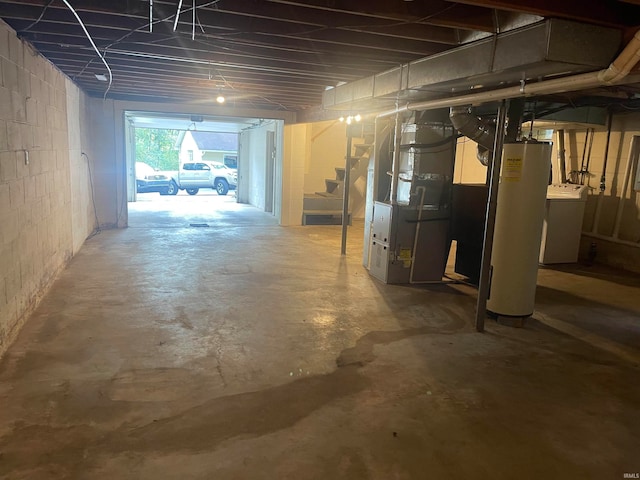 basement featuring water heater, heating unit, and washer / dryer