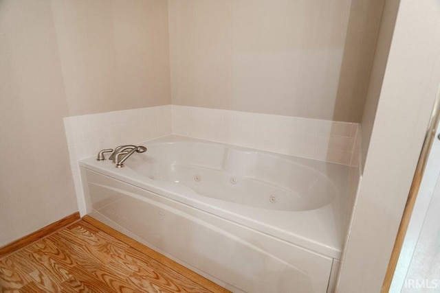 bathroom with hardwood / wood-style floors and a tub