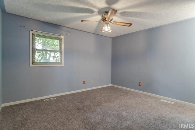 spare room with ceiling fan, a textured ceiling, and carpet