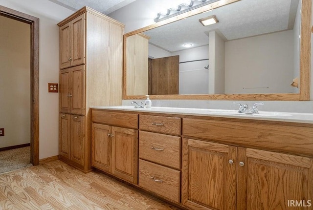 bathroom with a textured ceiling, hardwood / wood-style flooring, and vanity