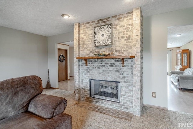 living room with a textured ceiling, a fireplace, and light carpet