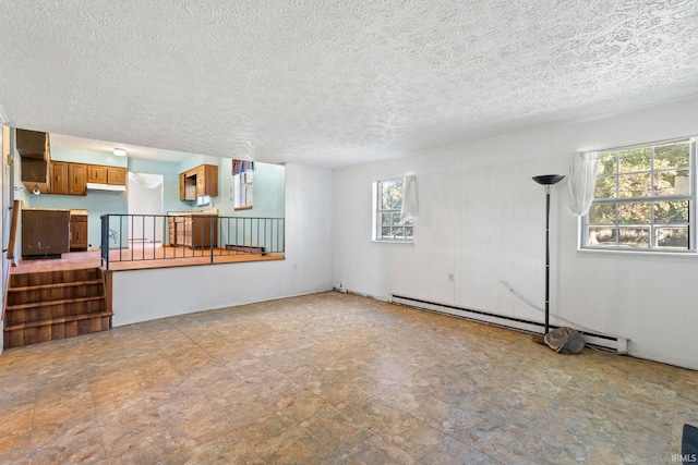 unfurnished living room with a wealth of natural light, a baseboard radiator, and a textured ceiling