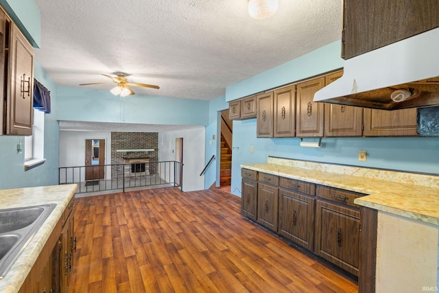 kitchen featuring dark wood-type flooring, ventilation hood, and a textured ceiling