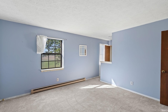 spare room with light carpet, a baseboard radiator, and a textured ceiling