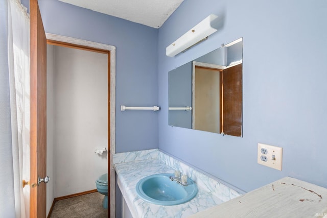 bathroom featuring vanity, toilet, and a textured ceiling