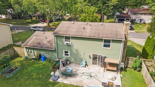 rear view of house featuring cooling unit, a lawn, and a patio