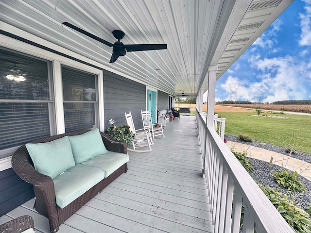 wooden terrace featuring an outdoor living space, ceiling fan, and a yard