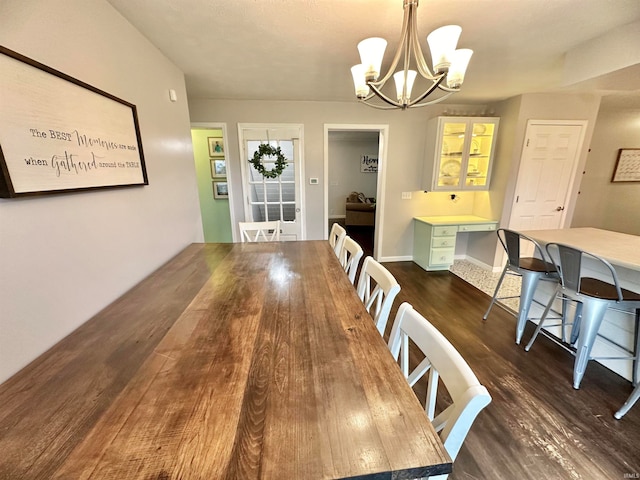 dining space with a notable chandelier and dark hardwood / wood-style floors