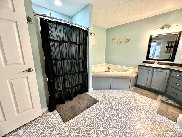 bathroom with a bathtub, a textured ceiling, and vanity