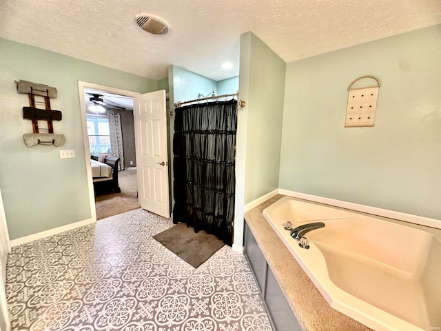 bathroom featuring a textured ceiling, ceiling fan, plus walk in shower, and tile patterned floors