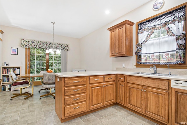 kitchen featuring pendant lighting, a wealth of natural light, kitchen peninsula, and sink