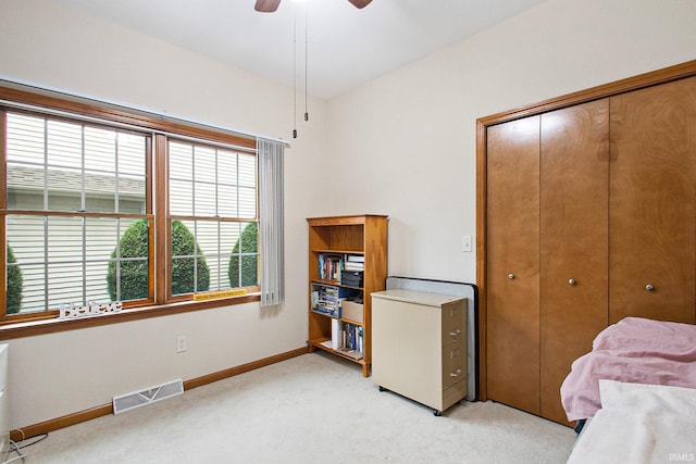 carpeted bedroom with ceiling fan and a closet