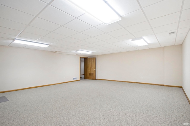 carpeted empty room featuring a paneled ceiling