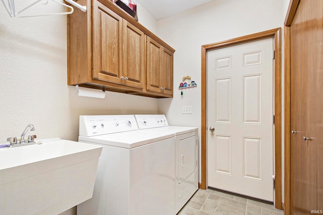 laundry room with cabinets, sink, and washing machine and dryer