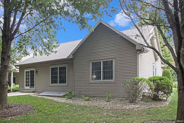 rear view of house with a lawn and a patio