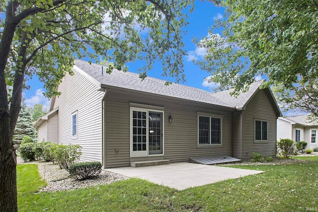 rear view of property featuring a lawn and a patio