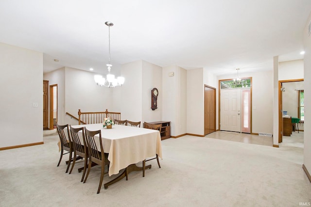 carpeted dining room featuring an inviting chandelier