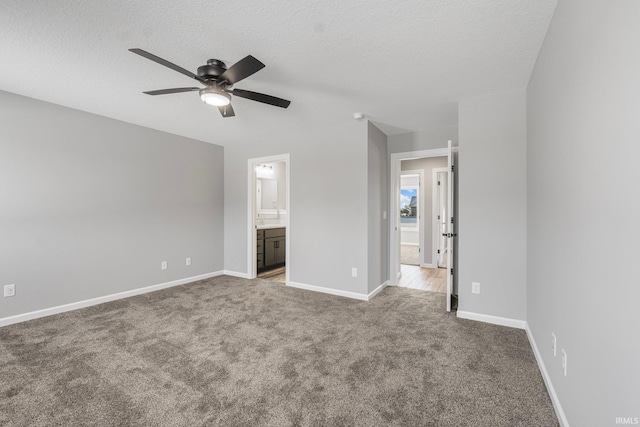 unfurnished bedroom featuring carpet, ceiling fan, a textured ceiling, and connected bathroom