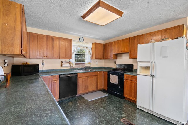 kitchen featuring black appliances, a textured ceiling, and sink