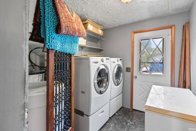 laundry room with a textured ceiling and washer and dryer