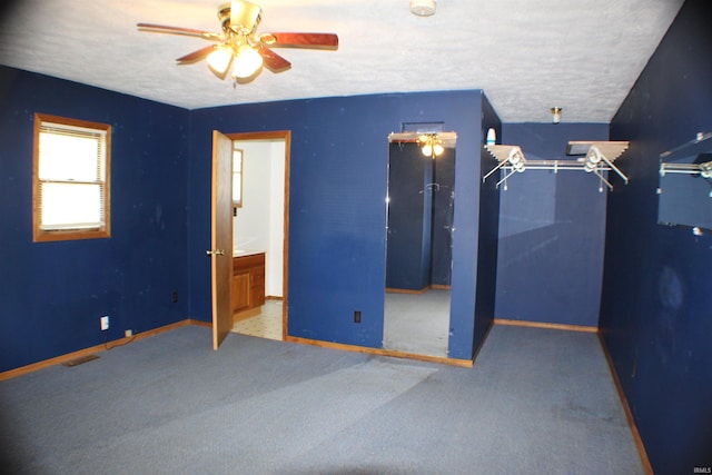 unfurnished bedroom with ceiling fan, carpet floors, and a textured ceiling