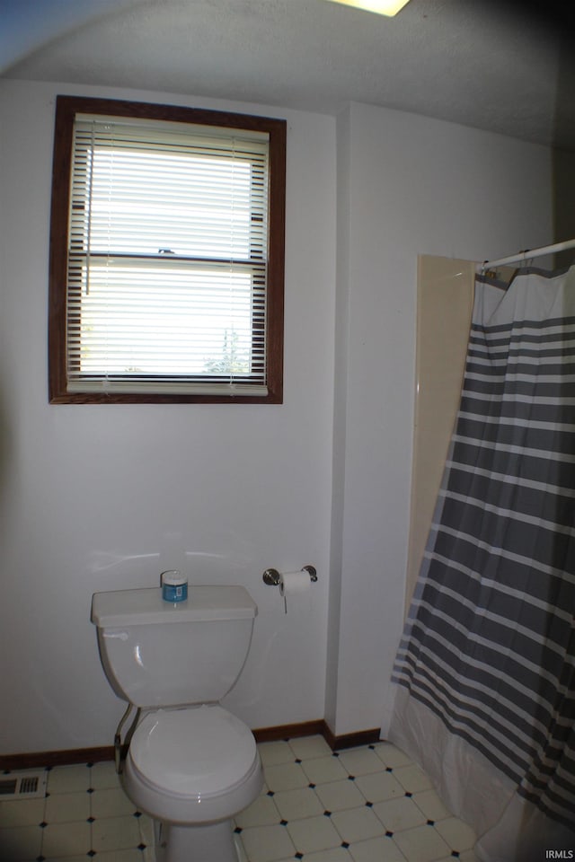 bathroom featuring walk in shower, a textured ceiling, and toilet