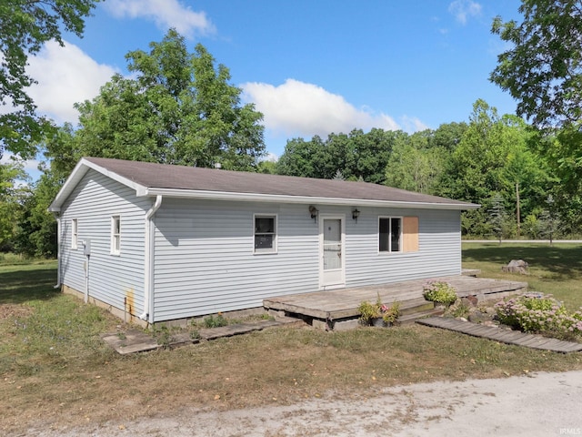 view of front of property featuring a deck and a front yard