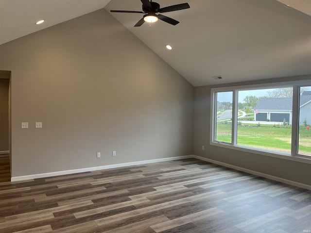 empty room with high vaulted ceiling, ceiling fan, and hardwood / wood-style floors