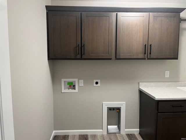 washroom featuring wood-type flooring, electric dryer hookup, hookup for a washing machine, and cabinets