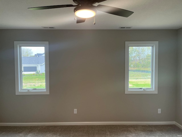 carpeted spare room featuring ceiling fan