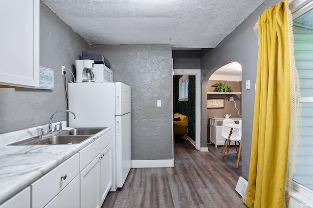 kitchen featuring white cabinets, sink, and a textured ceiling