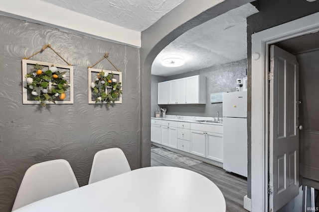 dining area with dark hardwood / wood-style flooring, a textured ceiling, and sink