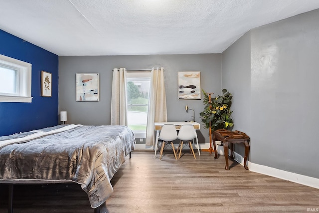 bedroom with wood-type flooring and a textured ceiling