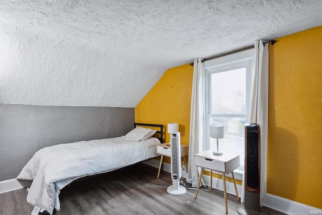 bedroom featuring wood-type flooring, a textured ceiling, and vaulted ceiling